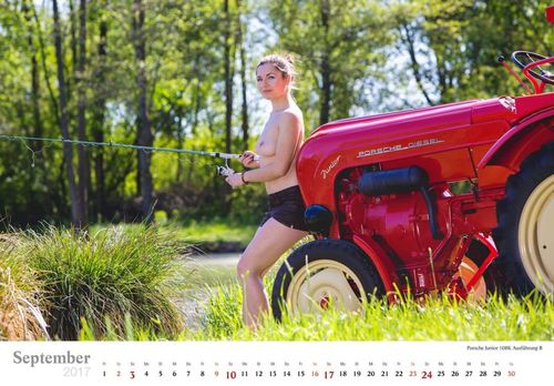 Topless model poseert met een hengel voor een oude rode tractor