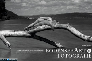 Naaktmodel liggend op een dode boom in het water