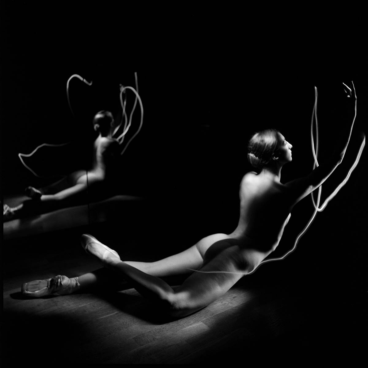 Naakte ballerina geaccentueerd door lightpainting met een spiegelbeeld